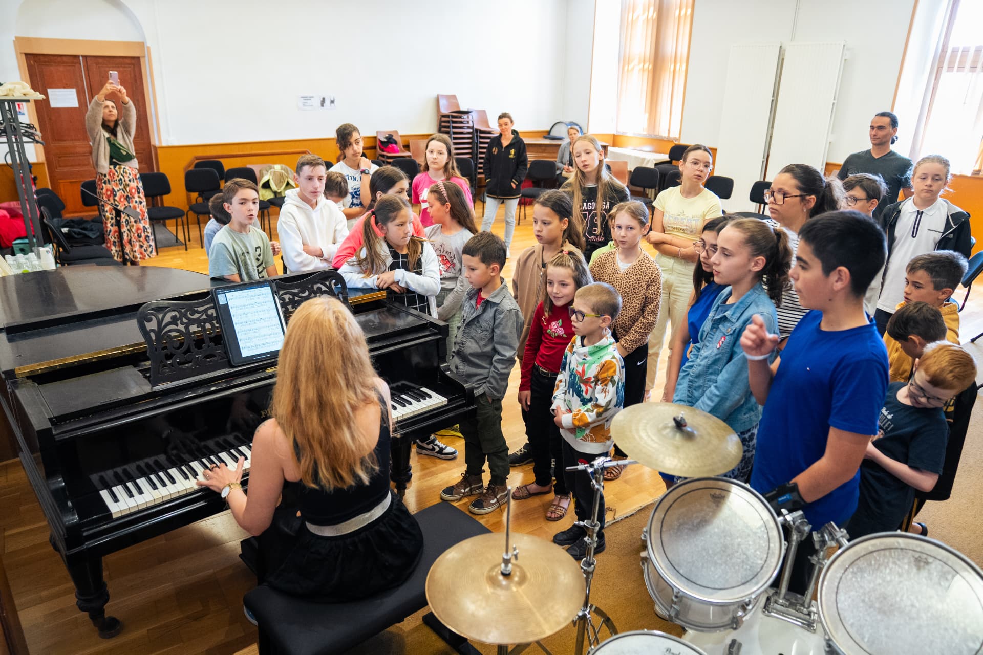 Un atelier de médiation culturelle : des enfants rassemblés autour d'une pianiste et d'une batterie