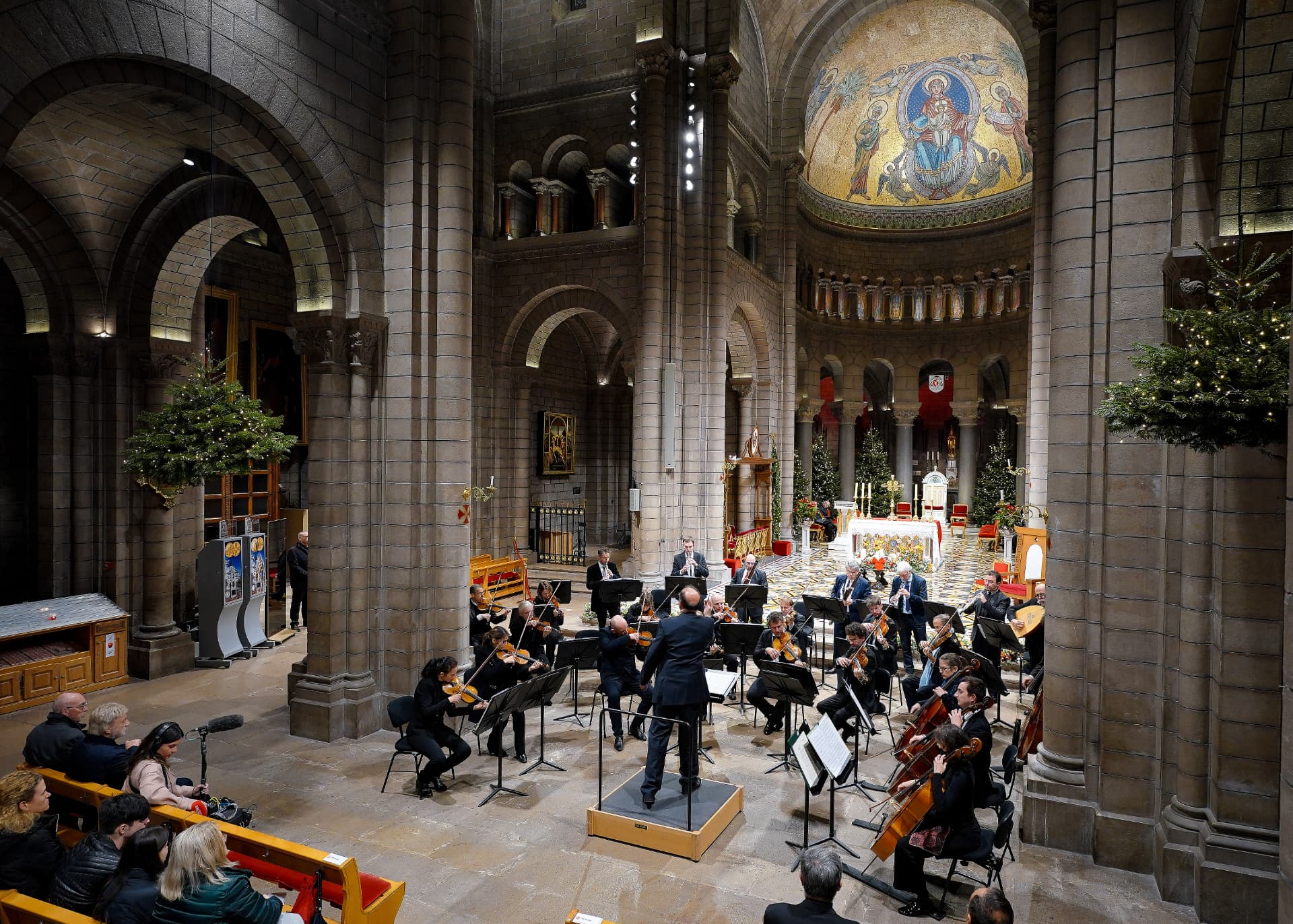 Un orchestre et son chef dans la nef richement décorée de la cathédrale